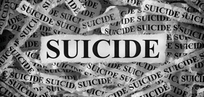 Torn pieces of paper with the words Suicide