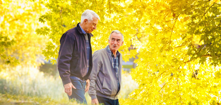 Senior gay couple enjoying a walk sunny Autumn day
