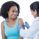 girl receiving vaccine from female doctor