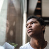 young black man looking at window