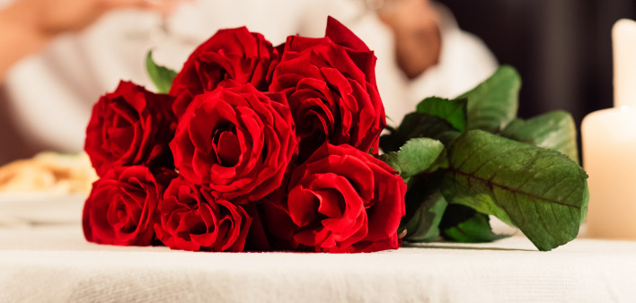 Valentine's Romantic Date. Red Roses Lying On Table, Unrecognizable Spouses Drinking Wine In