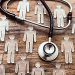 photo illustration figures and stethoscope on wood