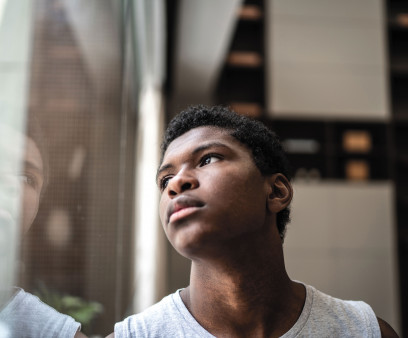 young black man looking at window