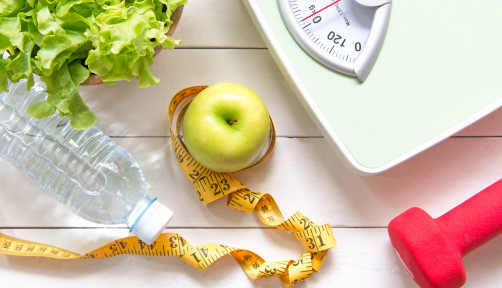Green apple and Weight scale,measure tape with fresh vegetable, clean water and sport equipment for women diet slimming