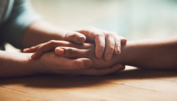 Shot of two people holding hands in comfort