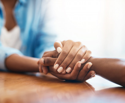 Closeup shot of two unrecognizable people holding hands in comfort at home