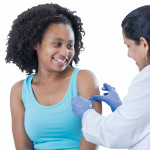 girl receiving vaccine from female doctor