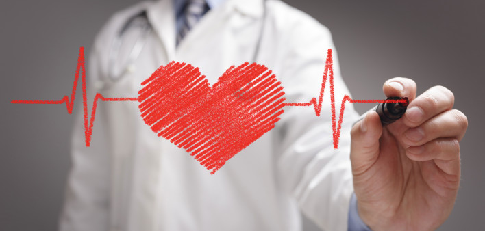 doctor in white coat drawing a red heart on glass