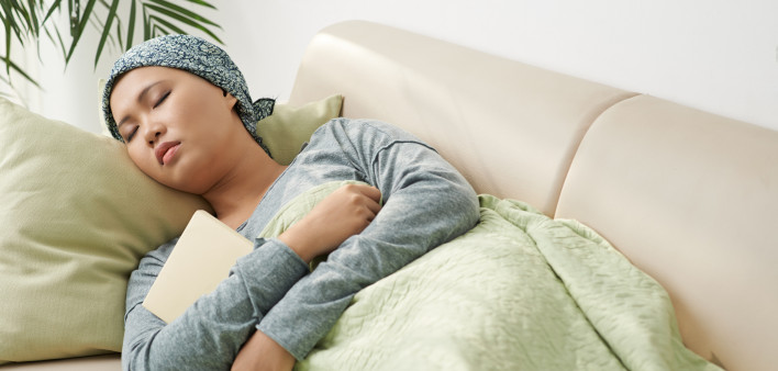 Asian woman with cancer sleeping on couch