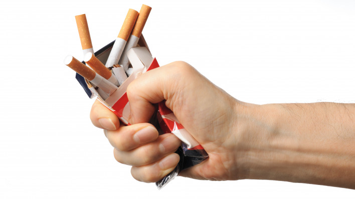 Hand crushing box of cigarettes