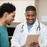 Doctor and patient looking at digital tablet in exam