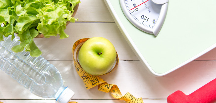 Green apple and Weight scale,measure tape with fresh vegetable, clean water and sport equipment for women diet slimming