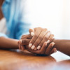 Closeup shot of two unrecognizable people holding hands in comfort at home