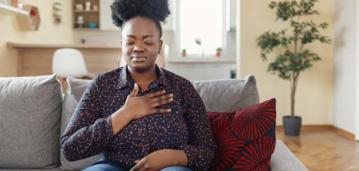 Pressure in the Chest. Close-up Photo of a Stressed Obese African American Woman Who Is Suffering From a Chest Pain and Touching Her Heart Area.