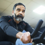 mature man exercise bike gym spin