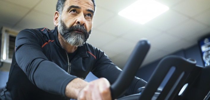 mature man exercise bike gym spin