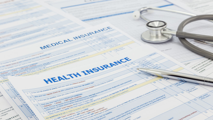 Medical insurance application, silver pen and stethoscope. Legal law contract and health insurance concepts.
