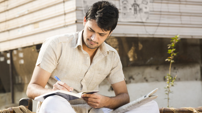 man taking notes writing in journal