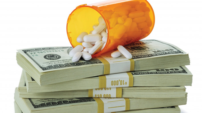 cost of healthcare bottle of pills on money