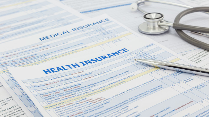 Medical insurance application, silver pen and stethoscope. Legal law contract and health insurance concepts.