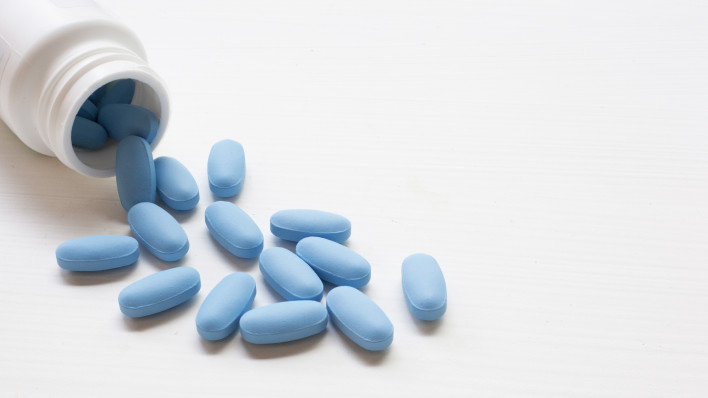 blue pills spilling out of bottle
