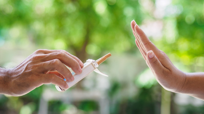 lose up of male hands holding cigarettes and proposing it to person.