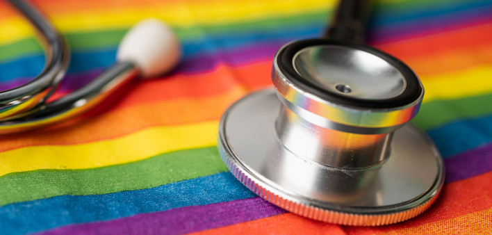 Black stethoscope on rainbow flag background,