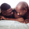 two gay black men in bed under covers