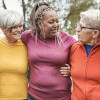 group of older women outside arm in arm smiling