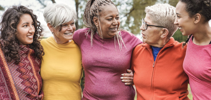 group of older women outside arm in arm smiling