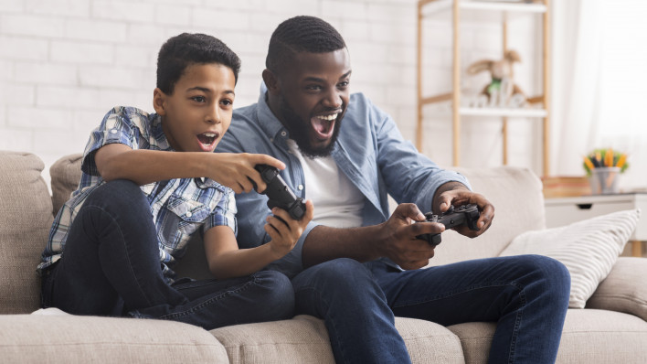 Leisure With Dad. Cheerful Black Father And Son Competing With Each Other In Video Games, Using Joysticks, Having Fun At Home,