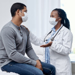 black doctor taklking to latin patient