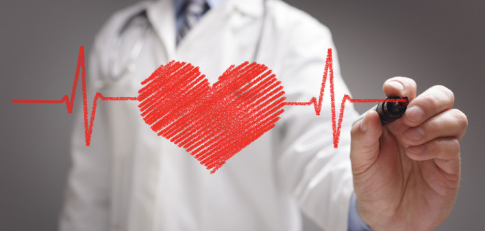 doctor in white coat drawing a red heart on glass