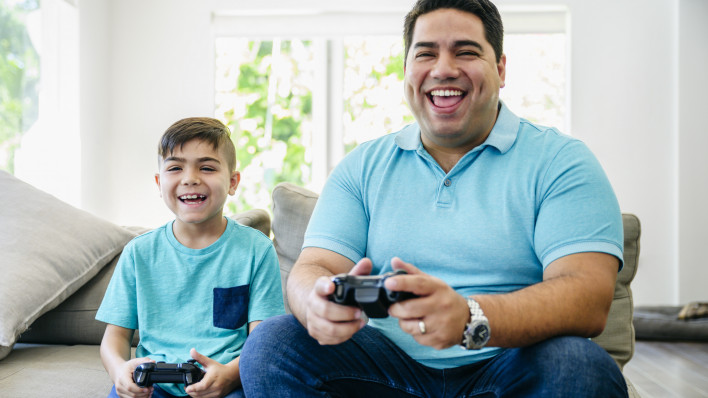 Fun-loving Latin American father and son playing video games