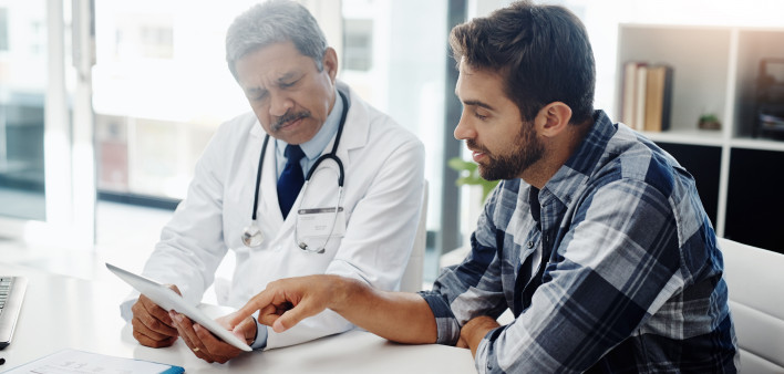 Cropped shot of a mature male doctor and patient having a discussion in the doctor's office before a checkup