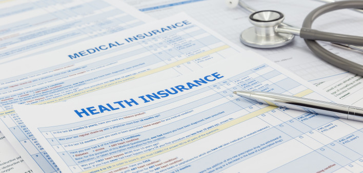 Medical insurance application, silver pen and stethoscope. Legal law contract and health insurance concepts.