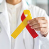 World hepatitis day and HIV/ HCV co-infection awareness with red yellow ribbon in medical doctor hand