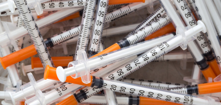 Close up of used syringes in the trash