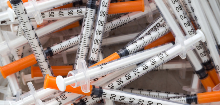 Close up of used syringes in the trash