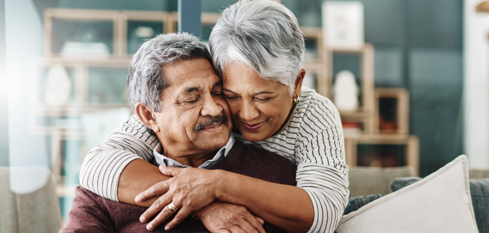 Cropped shot of a cheerful elderly woman hugging her husband who's in a wheelchair at home during the day