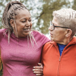 group of older women outside arm in arm smiling