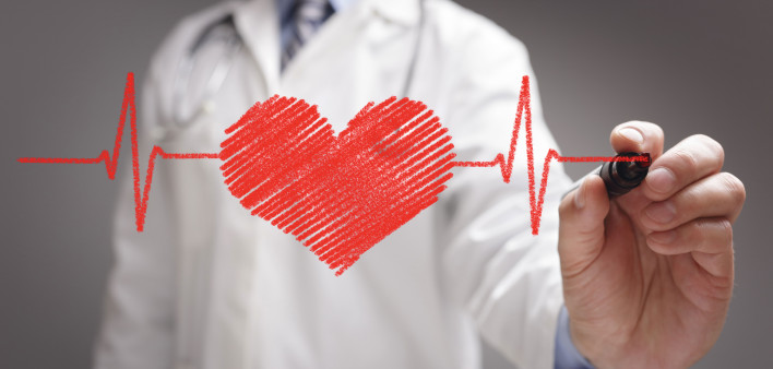 doctor in white coat drawing a red heart on glass