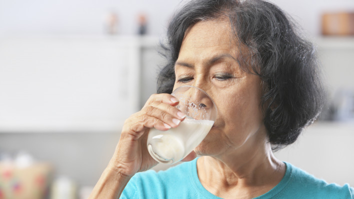 Senior Asian woman drinking milk at home(