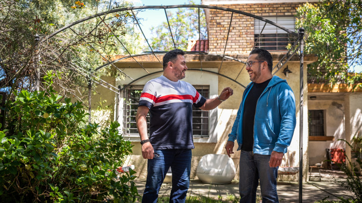 Two Latino men standing in backyard in Uruguay, the man on the right is living with HIV