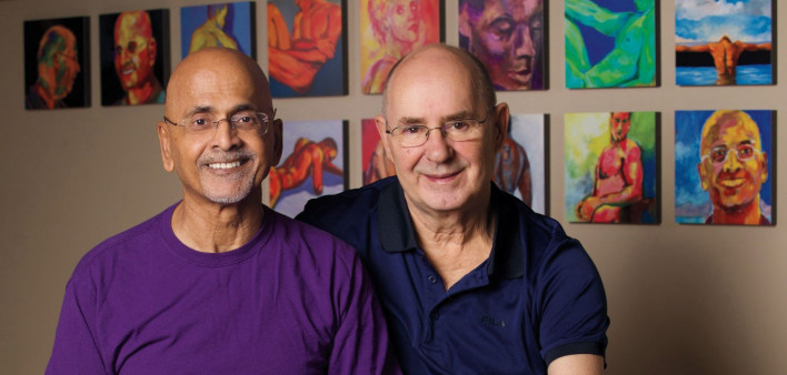 Vishwas and his husband, Joe, in front of Vishwas’s art in 2021
