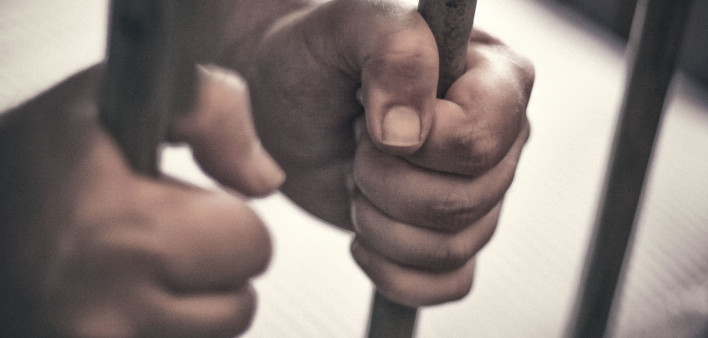 black hand hold prison bars