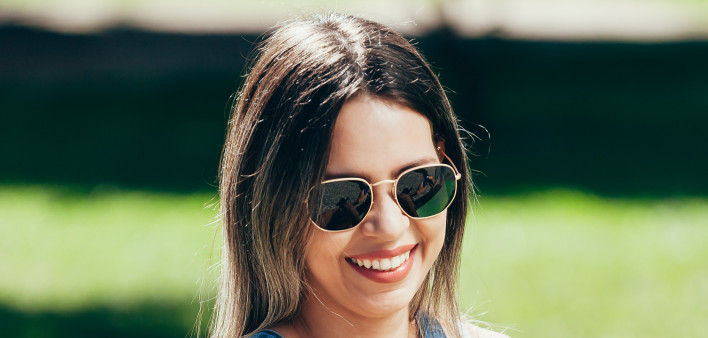 Young woman with sunscreen and sunglasses outside on a beautiful summer