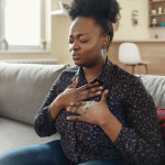 Pressure in the Chest. Close-up Photo of a Stressed Obese African American Woman Who Is Suffering From a Chest Pain and Touching Her Heart Area.