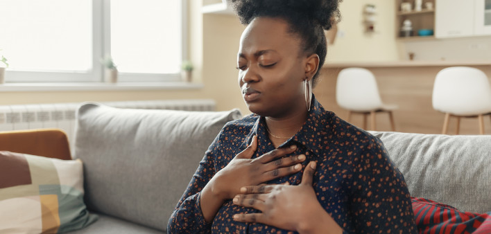 Pressure in the Chest. Close-up Photo of a Stressed Obese African American Woman Who Is Suffering From a Chest Pain and Touching Her Heart Area.
