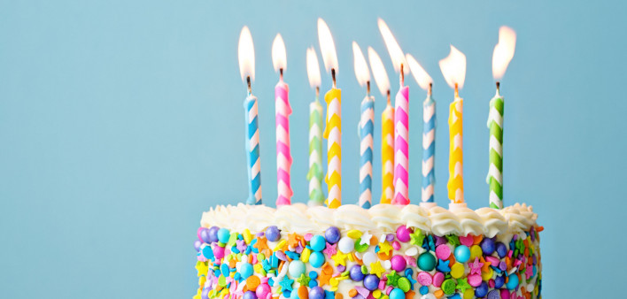 Birthday cake decorated with colorful sprinkles and ten candles